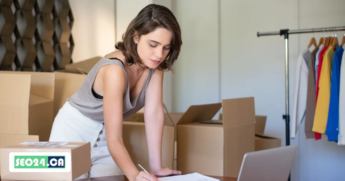 Online store owner working at a laptop among shipping boxes and a clothing rack, SEO24 e-commerce SEO service in Toronto